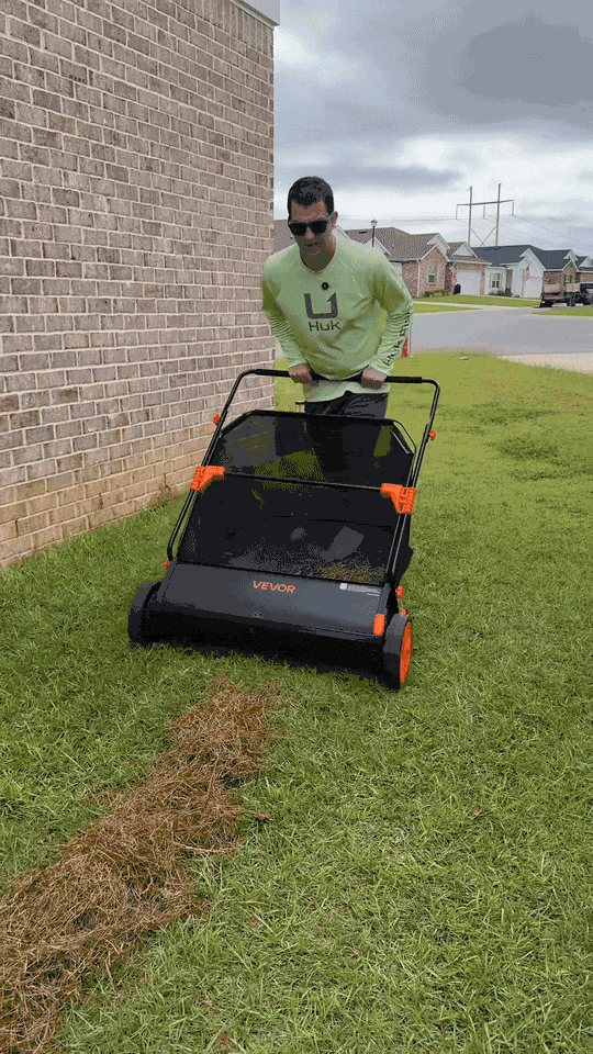 A homeowner pushing a lawn sweeper that picks up clippings in one pass